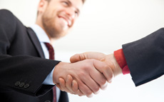 Photo of men in suits shaking hands